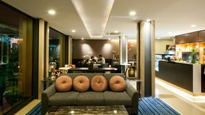 A modern hotel lobby with a sofa, a dining area, and a reception desk. - 41 Suite Bangkok (Bangkok)