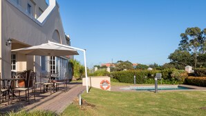 Um hotel com área de estar ao ar livre e piscina.