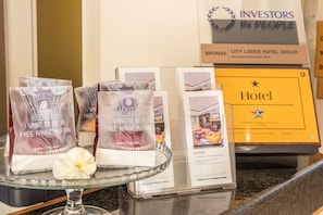 Una presentación de bolsas de muffins de gallinas camperas y un folleto del Grupo City Lodge Hotel sobre una encimera.