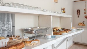 A buffet setup with bread, pastries, and beverages. - Pauba Beach Hotel (São Sebastião)