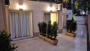 A modern building exterior with large sliding glass doors, potted plants, and a clean, tiled floor. - Pauba Beach Hotel (São Sebastião)