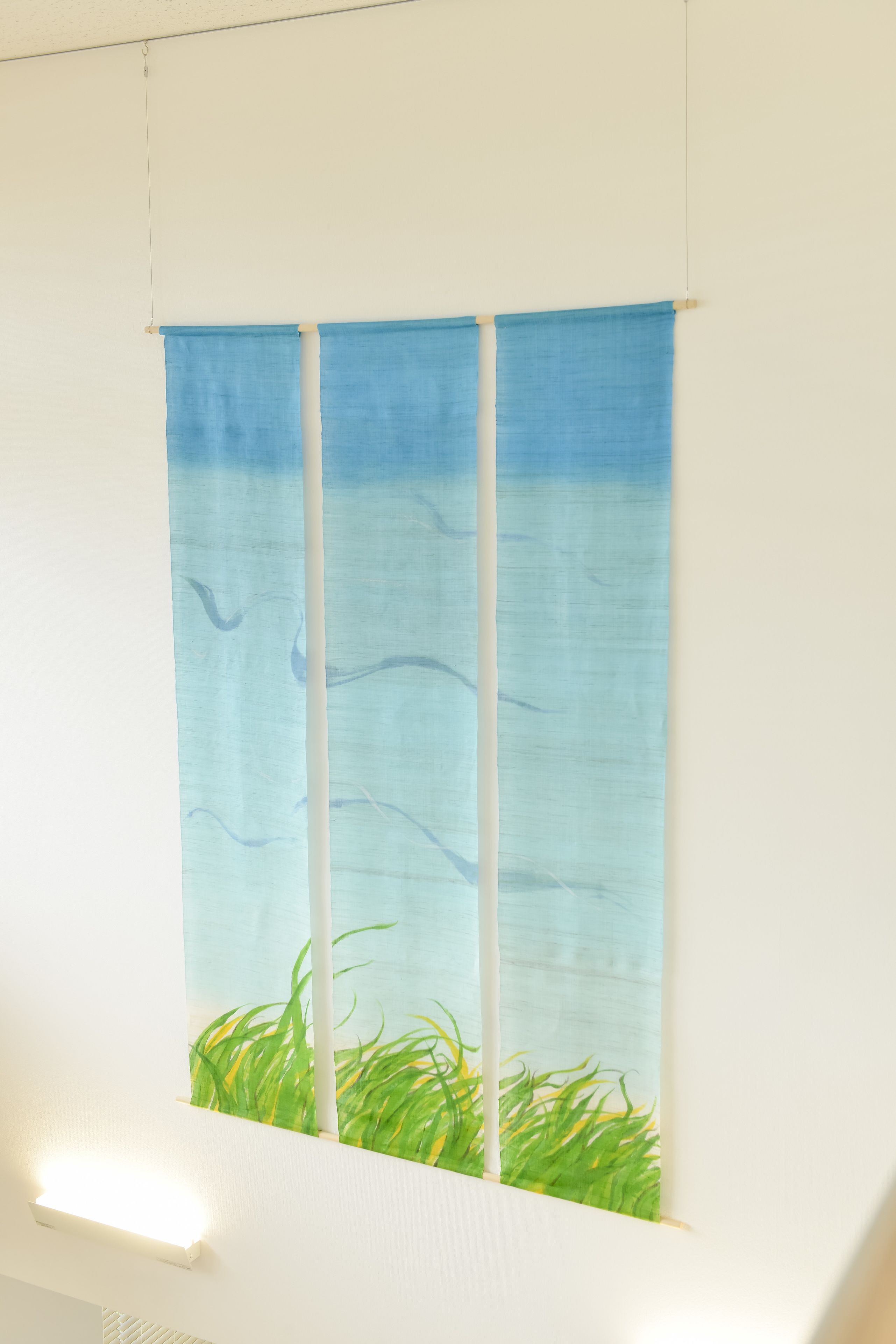 A wall with a blue and white abstract painting.