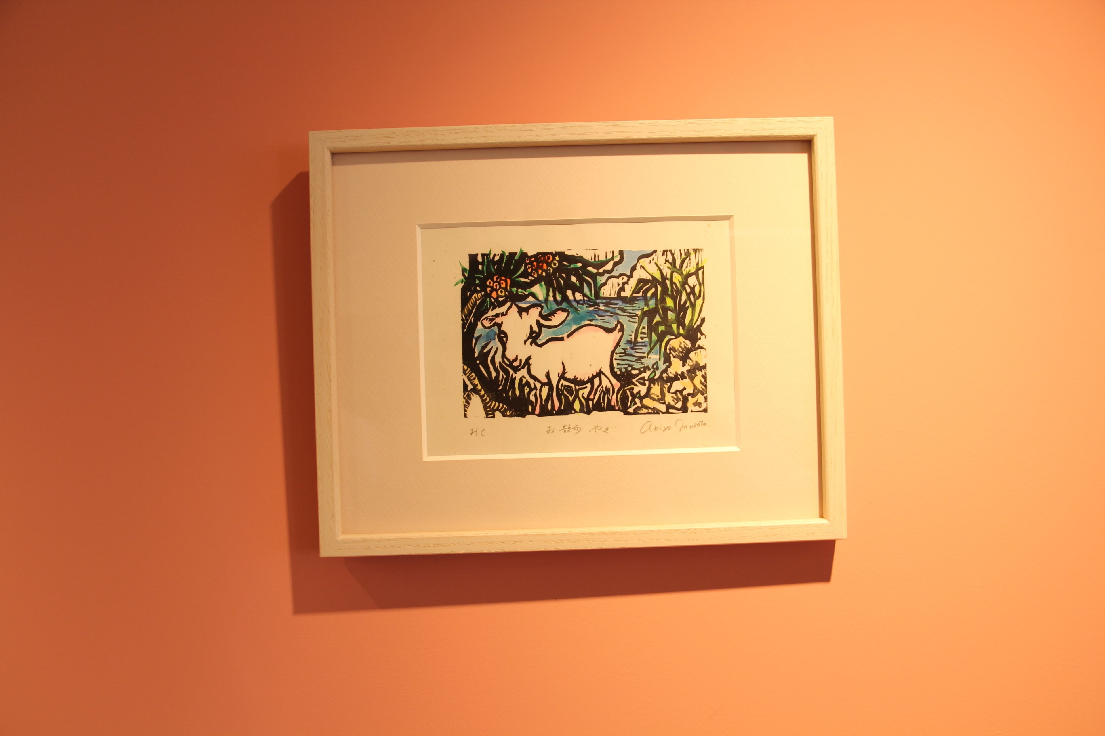 A framed artwork on an orange wall.