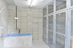 A bathroom with a bathtub, shower, and metal storage units.