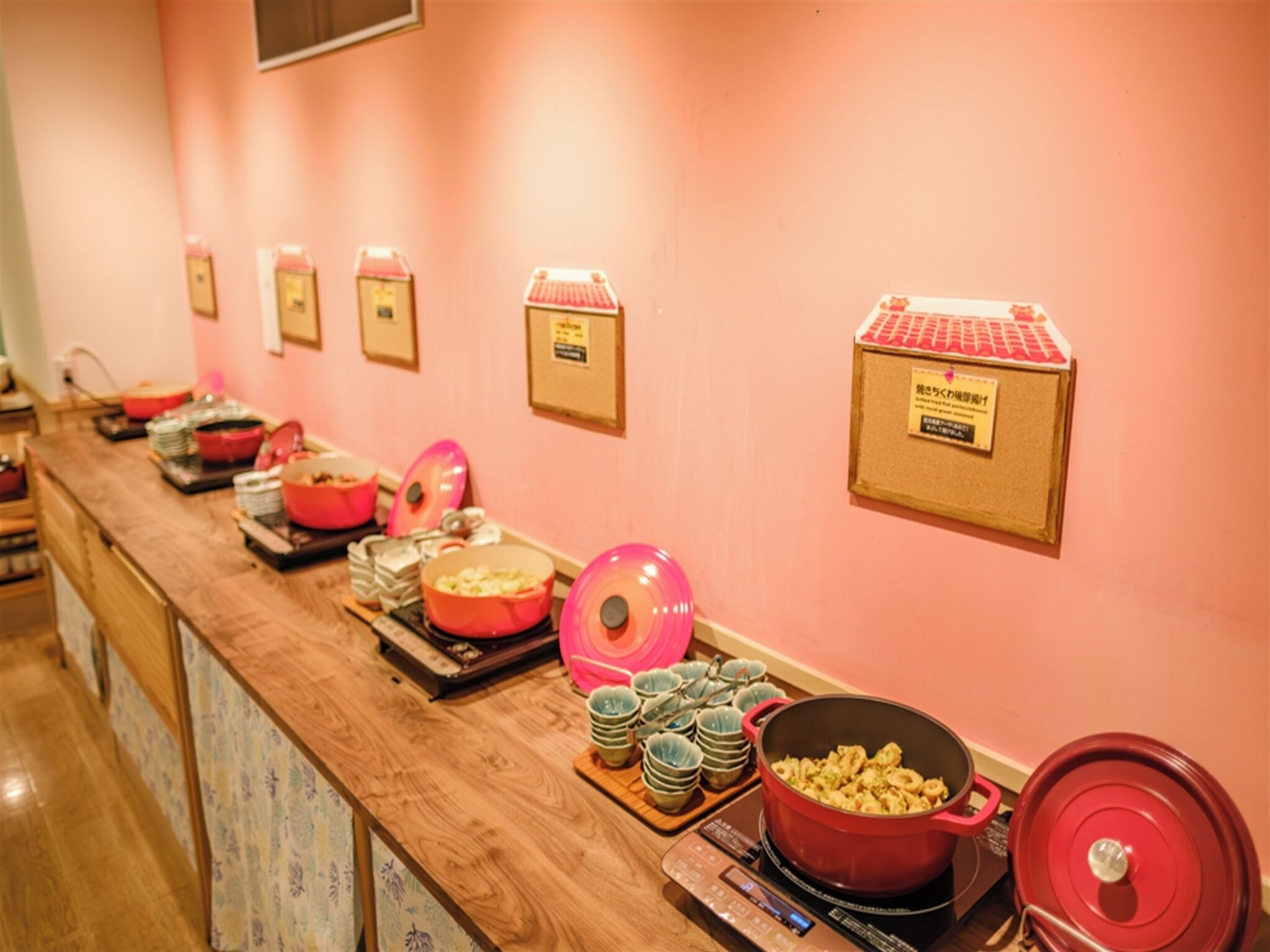 A buffet setup with various dishes and cooking equipment.