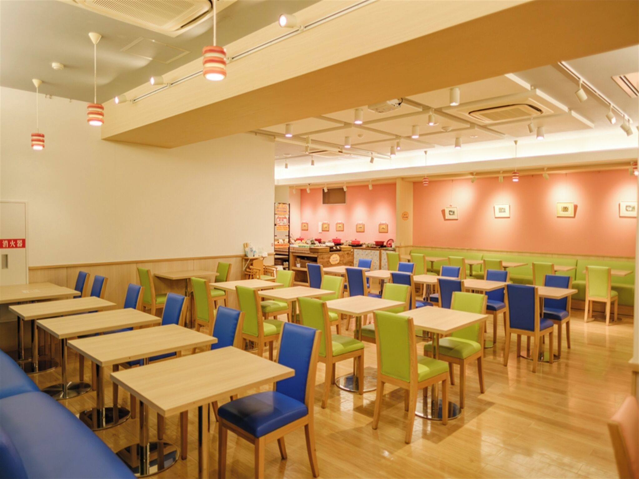 A restaurant with multiple tables and chairs, a counter with food items, and a sign indicating a fire extinguisher.