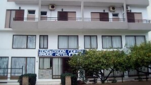 A multi-story hotel with balconies, air conditioning units, and a sign for the Eend Alliance Bridge Hotel. - Hotel Gefyra (Agios Nikolaos)