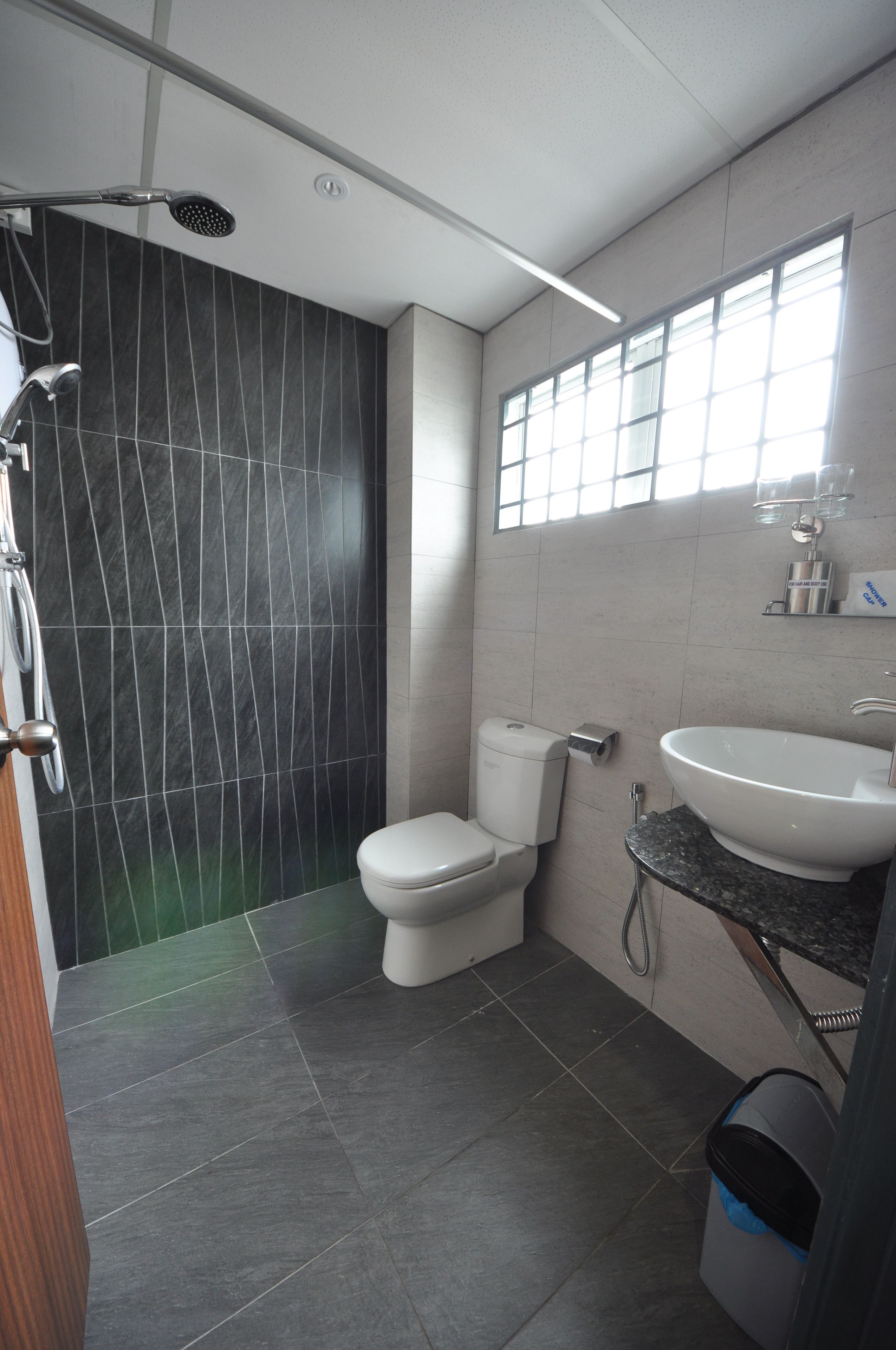 Et moderne badeværelse med bruser, toilet og vask.