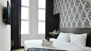 A hotel room with a bed, a nightstand, a mirror, and a TV mounted on the wall. - Le Metrotel (Ipoh)