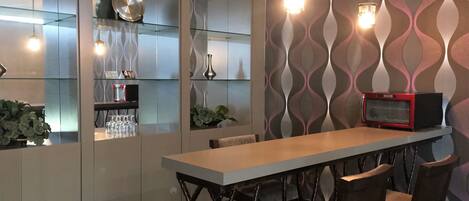 Una cocina moderna con una isla central, armarios con puertas de vidrio y un microondas en la pared.