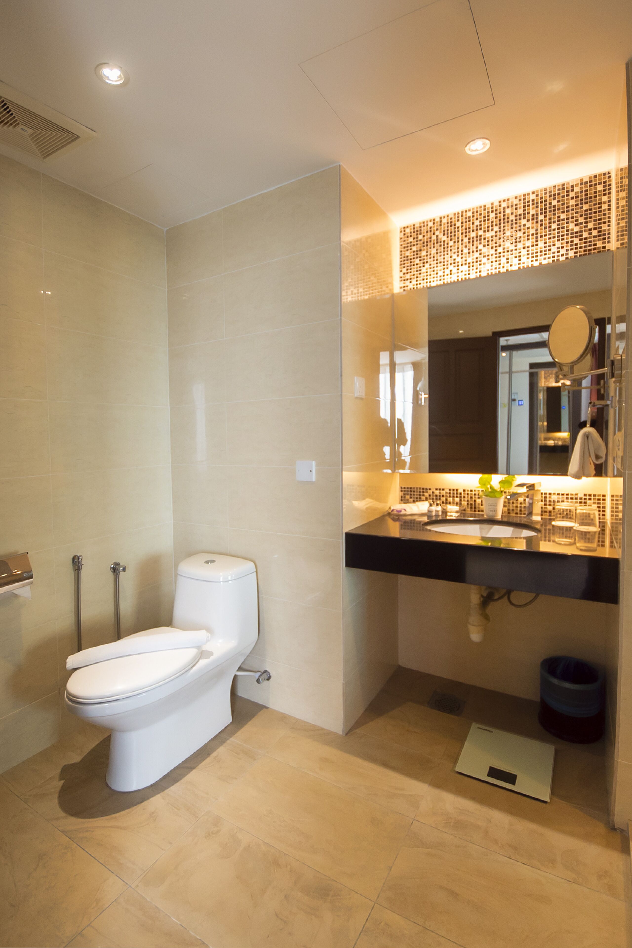 A modern bathroom with a toilet, sink, and shower.
