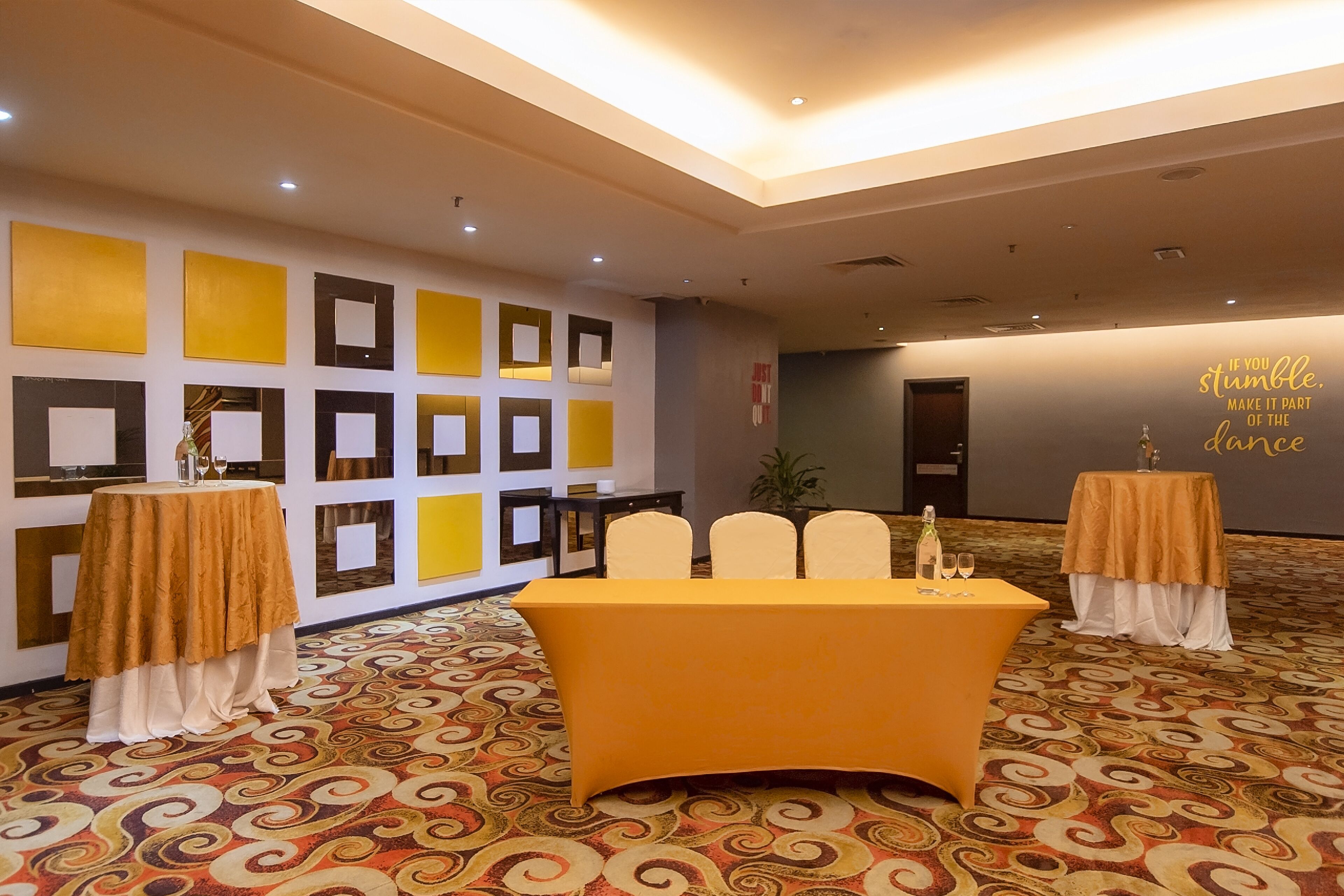 A conference room with a central table, chairs, and a patterned carpet.