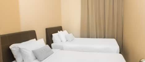 A hotel room with two beds, a ceiling light, an air conditioning unit, and a curtain.