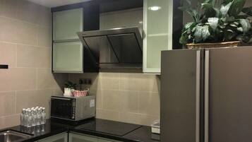A kitchen with a refrigerator, microwave, and cabinets.