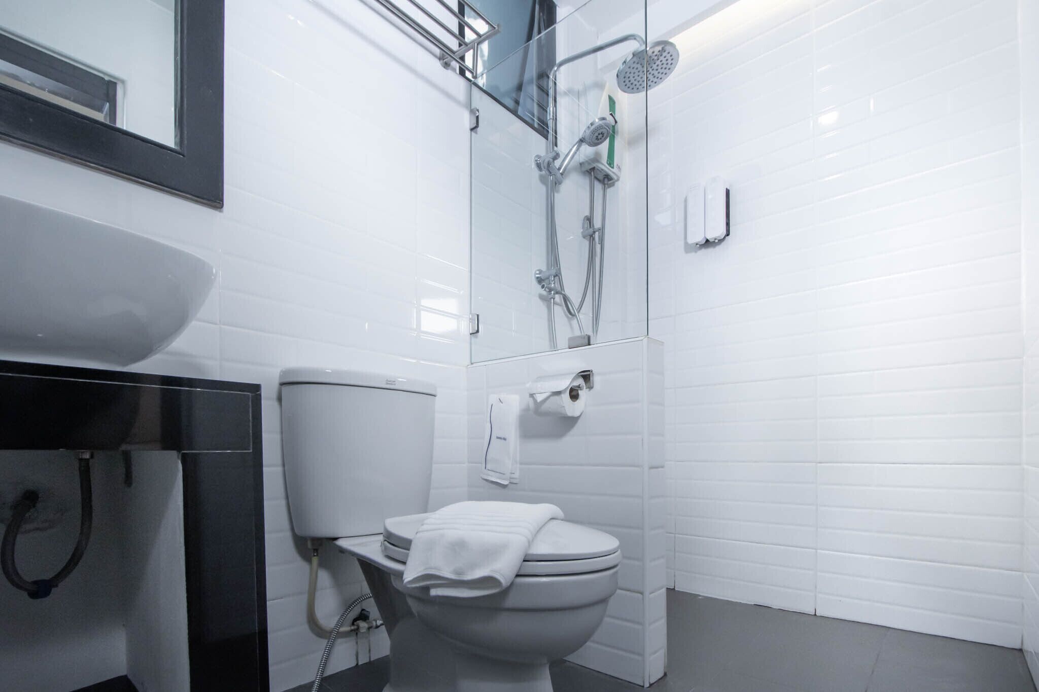 A modern bathroom with a toilet, sink, and shower.