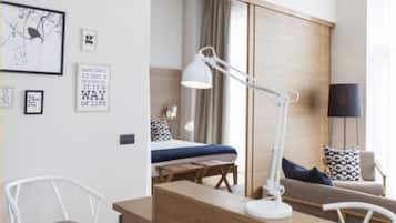 Ett modernt hotellrum med en säng, ett skrivbord, en stol och en lampa.