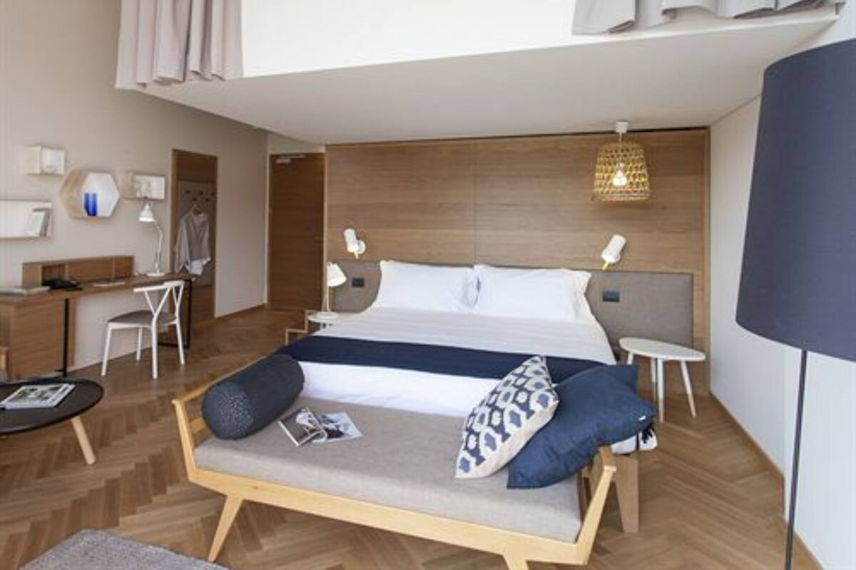 Une chambre d’hôtel moderne, dotée d’un grand lit, d’un bureau et d’un coin salon.