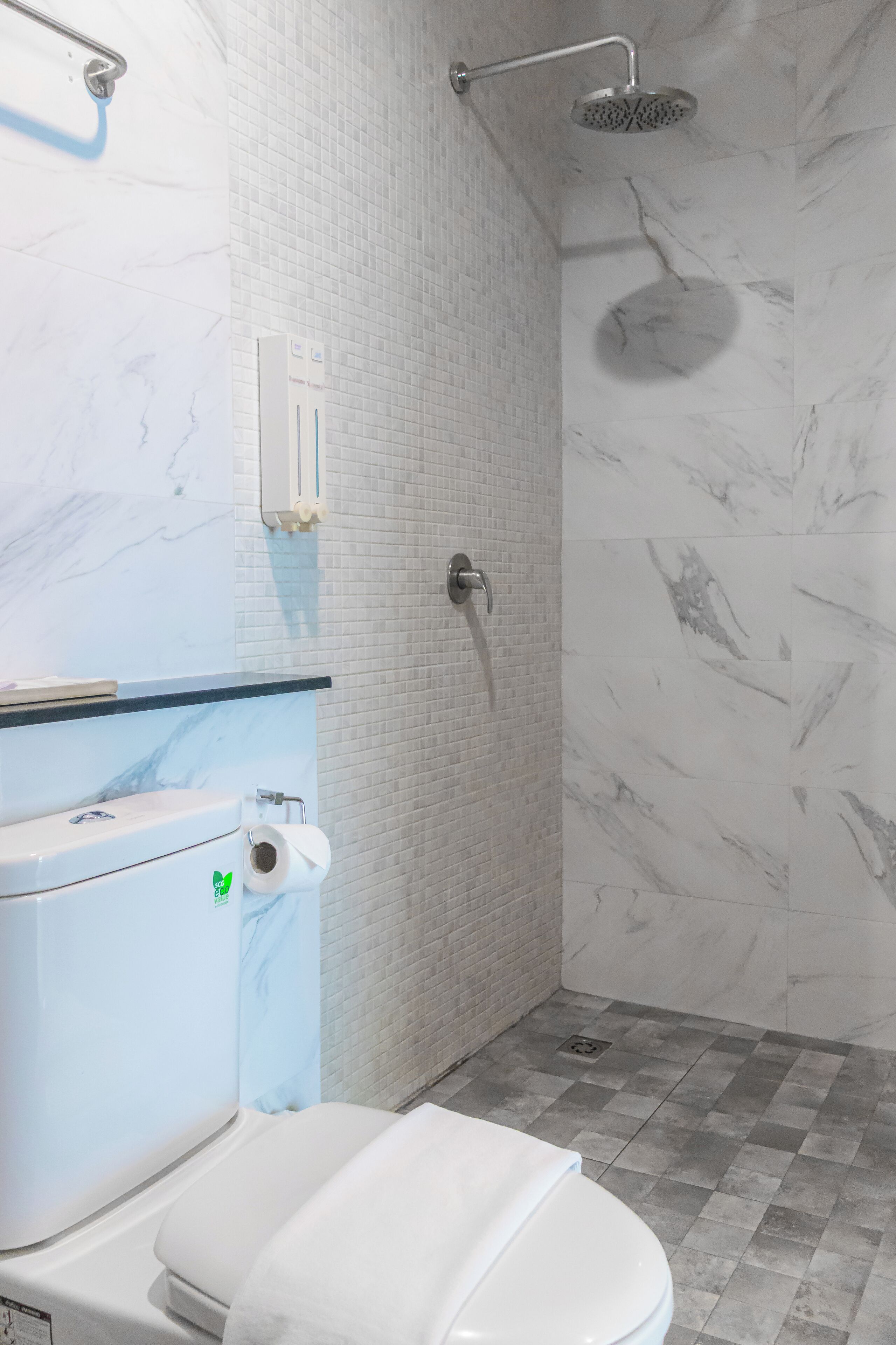 A bathroom with a toilet, a shower, and a sink.