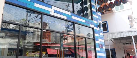 Un edificio con fachada azul y blanca a rayas, ventanas amplias y un cartel que dice "The Blue Pearl".