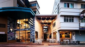 Un hotel con un patio central, zona de estar al aire libre y fachada moderna.
