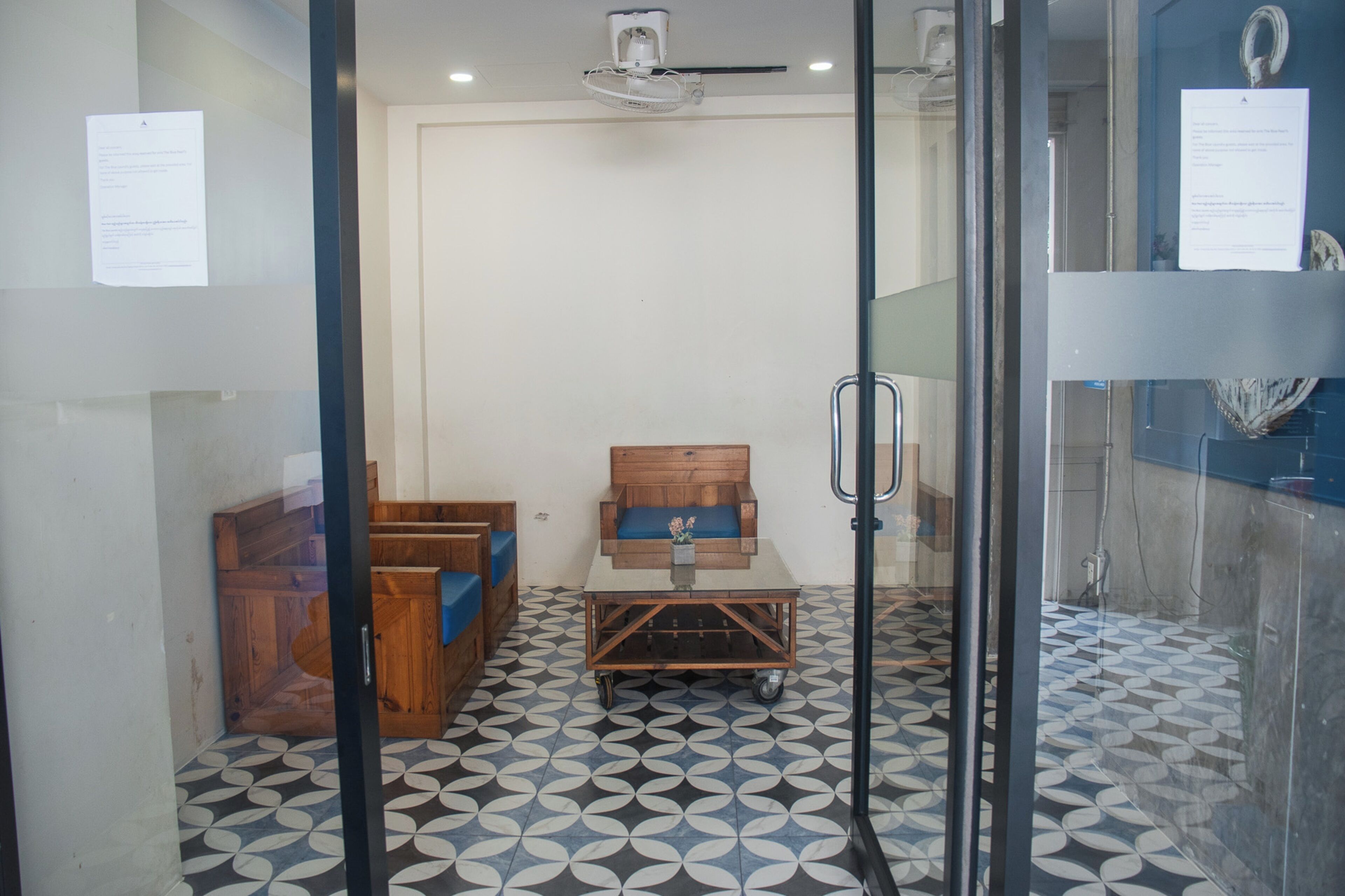 A room with a wooden bench, a small table, and a patterned floor.
