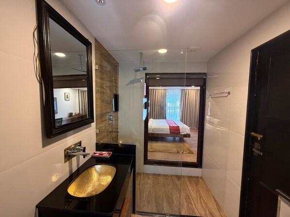 A modern bathroom with a large mirror, a black sink, and a shower area. - Ambassador Garden Home (Kathmandu)