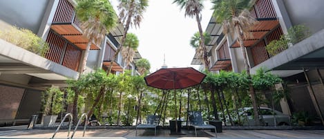 Alberca al aire libre, sombrillas en la alberca y camastros