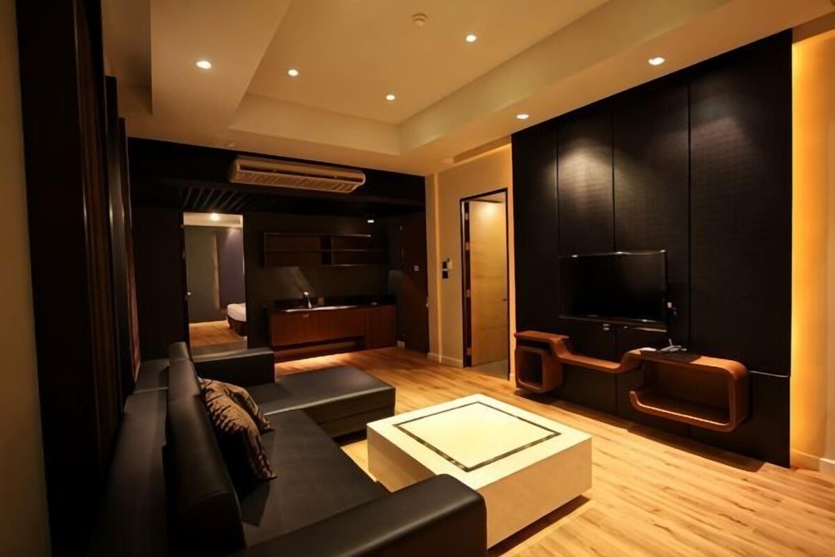 Una sala de estar moderna con un sofá, una mesa de centro, un televisor y un aparador.