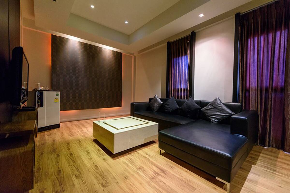 Uma sala de estar moderna com um sofá seccional, uma mesa de centro e uma televisão de tela plana.