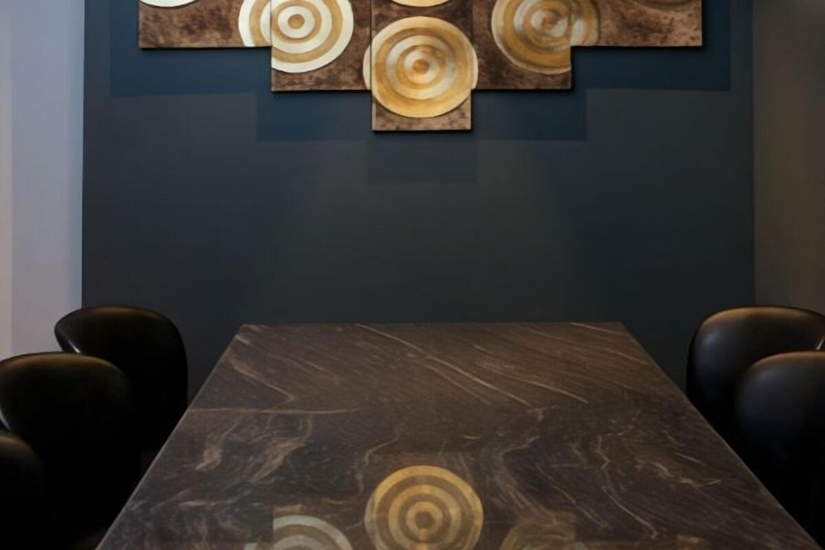 Una sala de conferencias con una mesa de mármol y sillas de cuero.