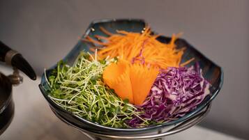Eine Schüssel mit geriebenen Karotten, violettem Kohl und Sprossen.