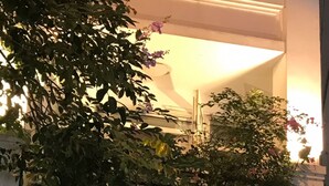 La entrada del Hanoi Garden Hotel & Spa, con un letrero, plantas en macetas y un mostrador de recepción.