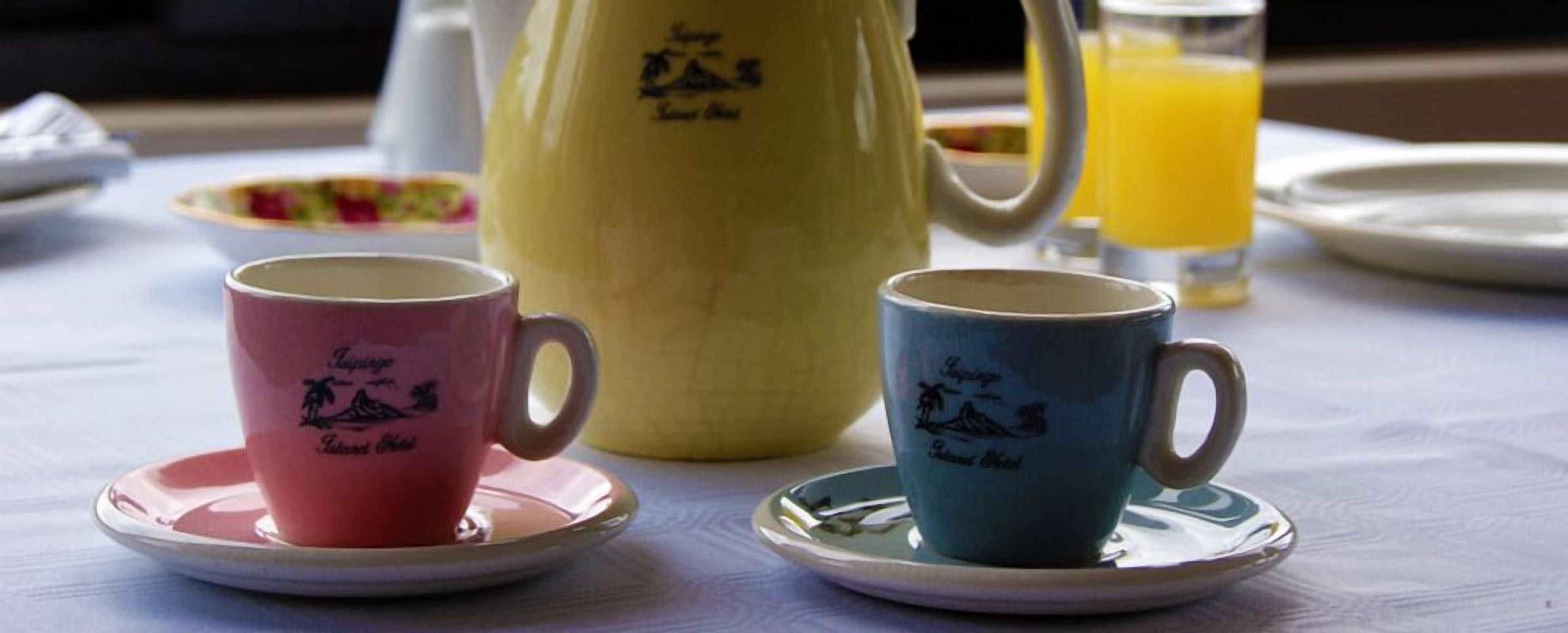 Dos tazas con sus platillos sobre una mesa.