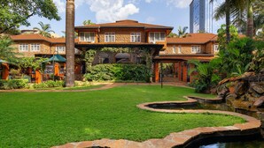 A large, two-story house with a stone facade, a well-maintained lawn, and a small pond. - Fairview Hotel Nairobi, Vignette Collection by IHG (Nairobi)