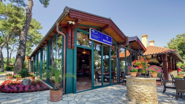 A restaurant with a stone patio, outdoor seating, and potted plants. - The Mediterranean Village San Antonio (Biograd na Moru)