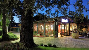 A glass-enclosed outdoor dining area with stone flooring and potted plants. - The Mediterranean Village San Antonio (Biograd na Moru)