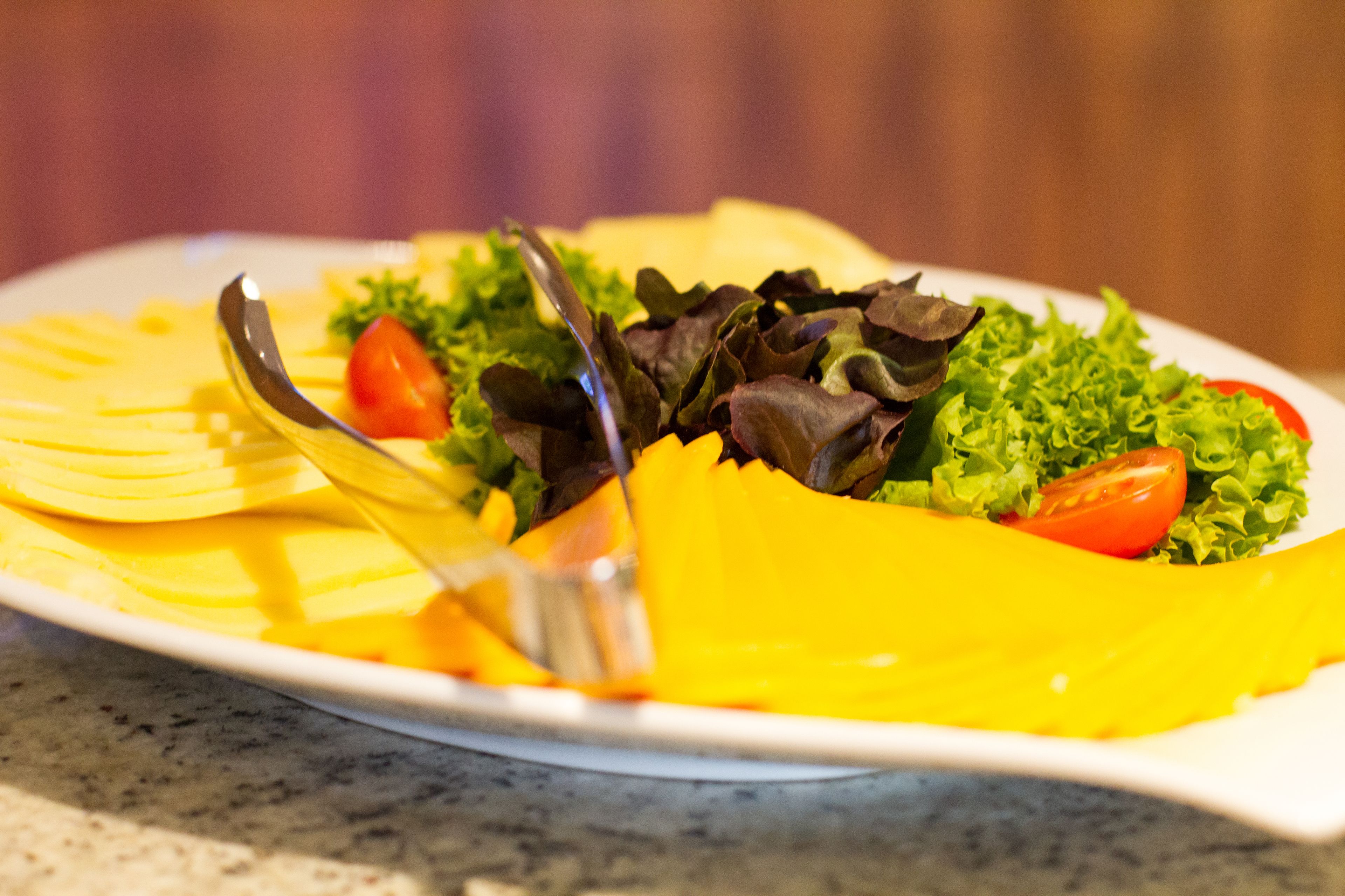 A plate of food with a fork and knife on a marble countertop.