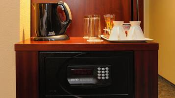 A coffee machine, two cups, and a glass on a wooden counter.
