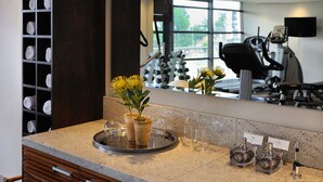 Ein Badezimmer mit Granitwaschtisch, Waschbecken, Spiegel, Handtuchhalter und einem Blumentopf.