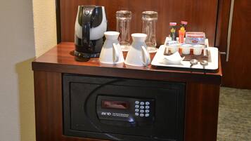 A coffee station with a coffee maker, pitchers, and condiments.