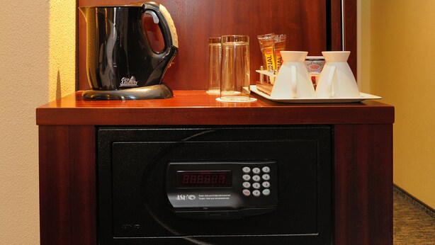 A coffee machine, two cups, and a glass on a wooden counter. - City Lodge Hotel Fourways (Sandton)