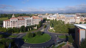 A large hotel with multiple floors, a central courtyard, and a view of the surrounding cityscape.