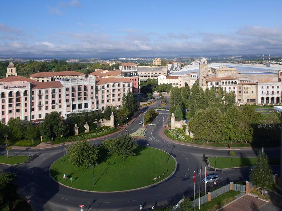 A large hotel with multiple floors, a central courtyard, and a view of the surrounding cityscape.