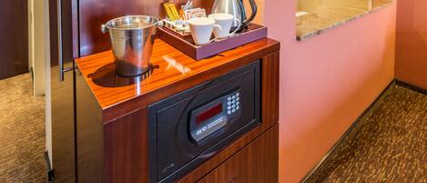 Una zona de cocina con cafetera, hervidor y una bandeja con tazas y una caja de pañuelos.