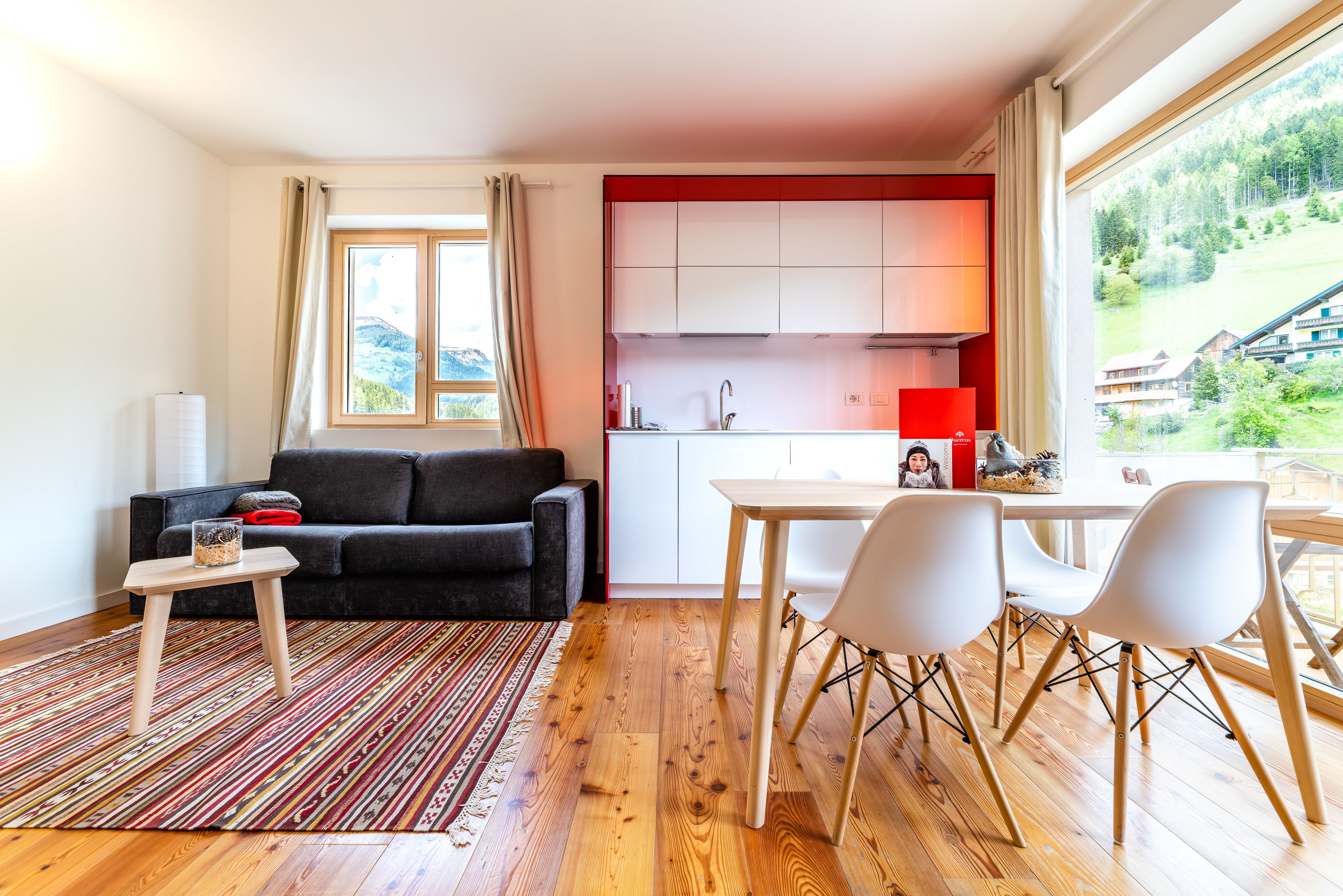 Ein modernes Wohnzimmer mit Sofa, Couchtisch und Blick auf eine Küche.