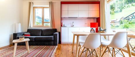 Una sala moderna con un sofá, una mesa de centro y vistas a una cocina.
