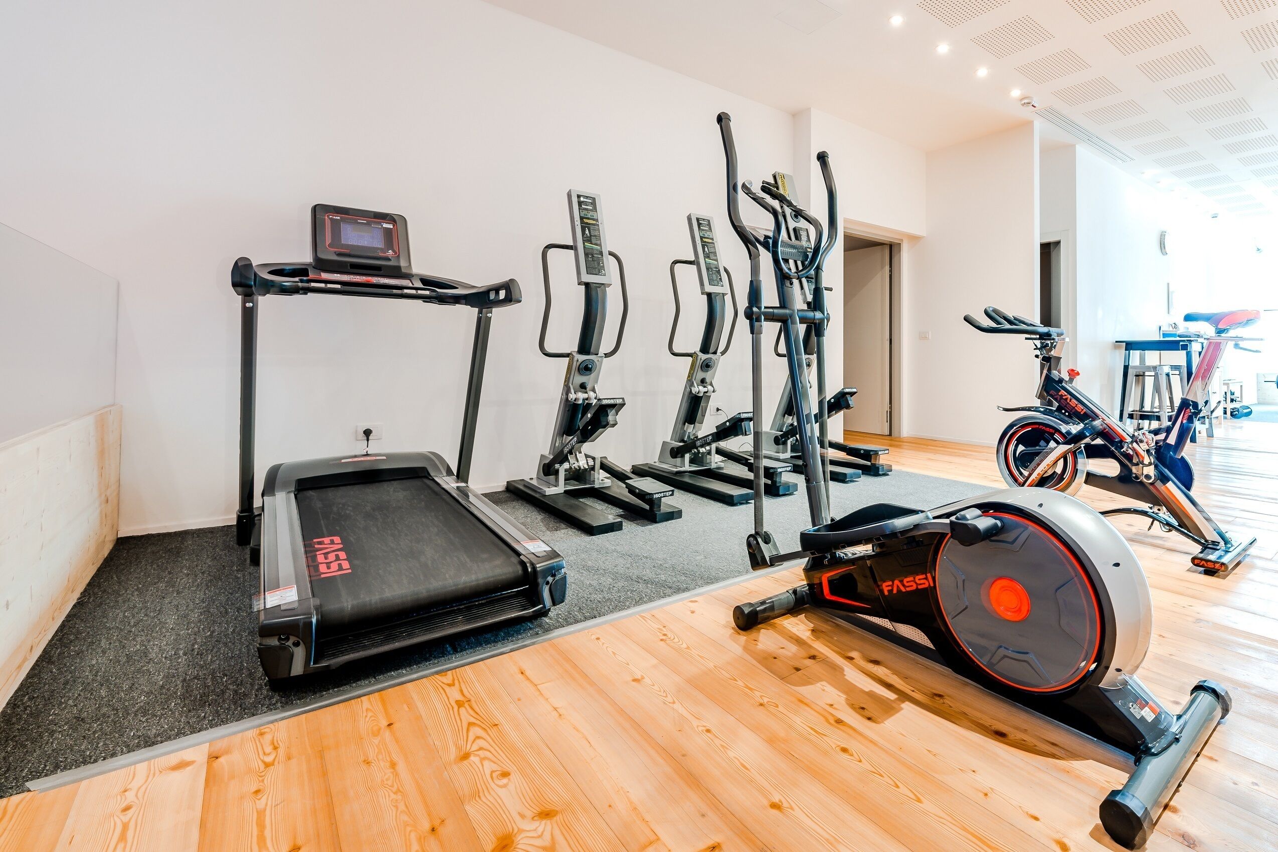 A gym with various exercise equipment including treadmills, ellipticals, and a stationary bike.