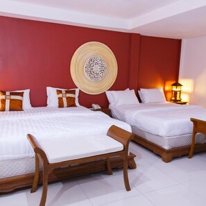 Habitación de hotel con dos camas, un tapiz decorativo, una lámpara de noche y un teléfono en la mesita de noche.