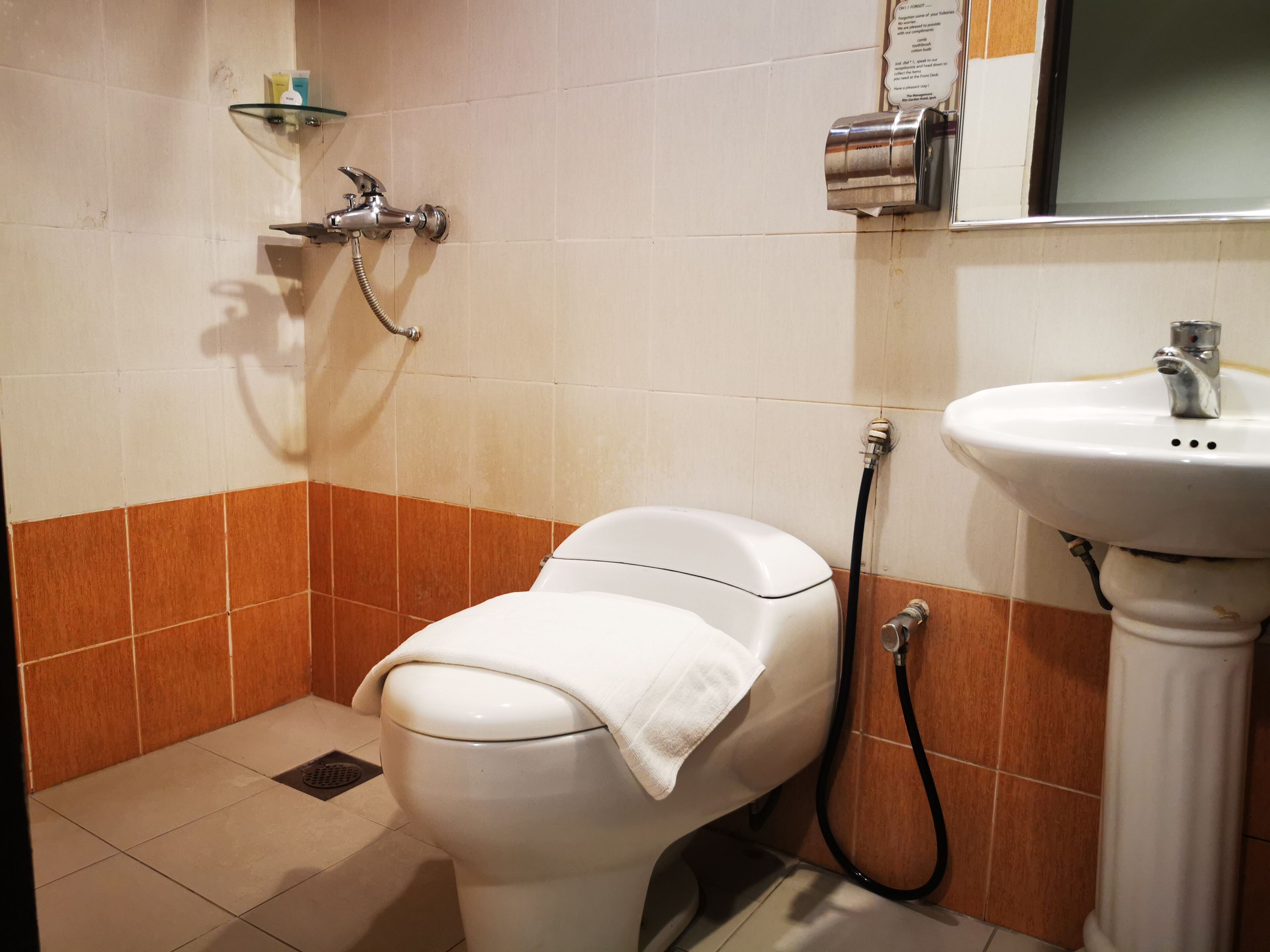 A bathroom with a toilet, a shower, and a sink.