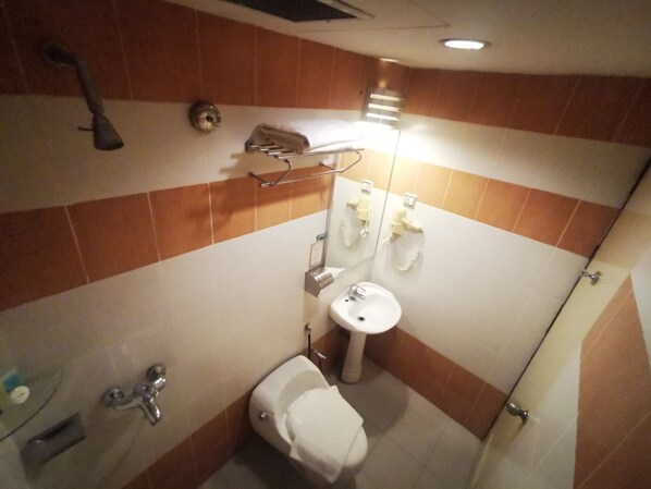 Un baño pequeño con inodoro, lavabo y ducha.